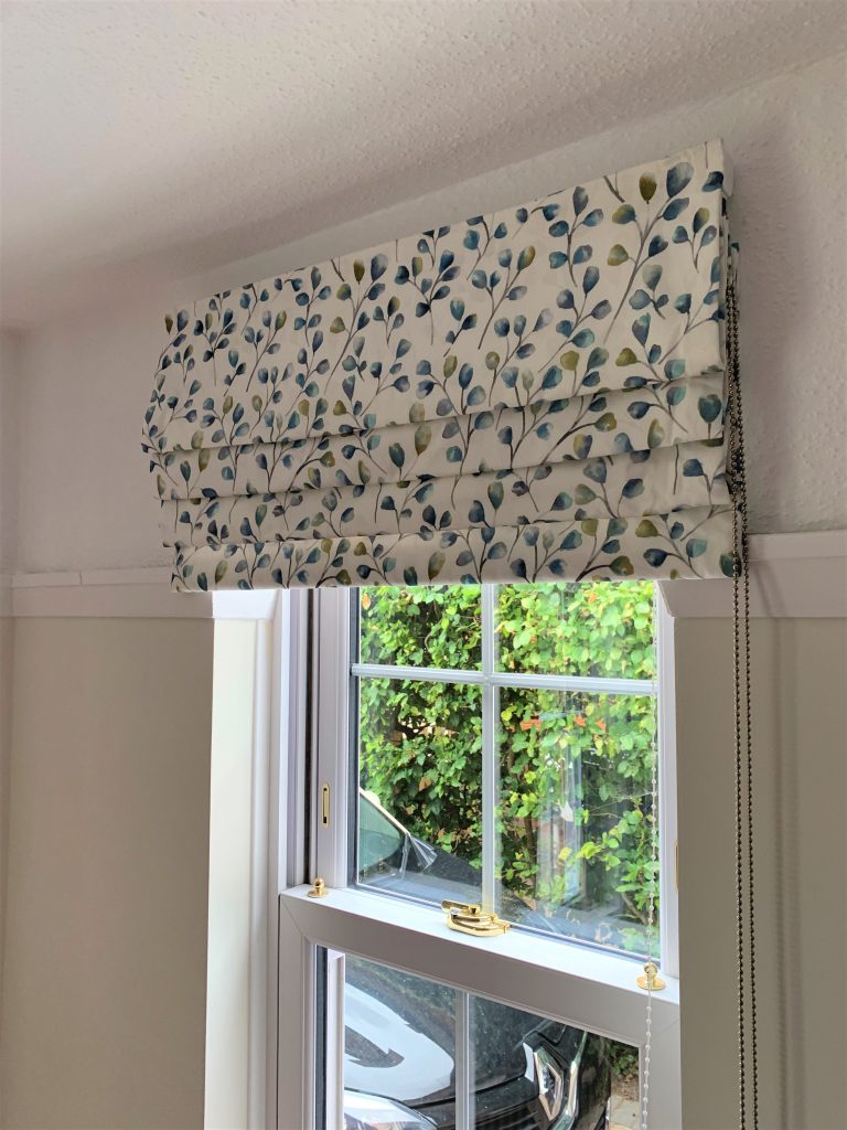 Store bateau sur mesure en tissu imprimé avec motif feuilles bleu/vert, commande à chaînette latérale, Intérieurs Inspirés.